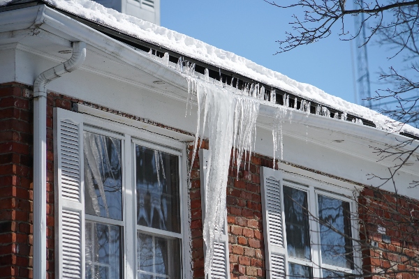 A home's gutters bend under the weight of melting snow and ice.
